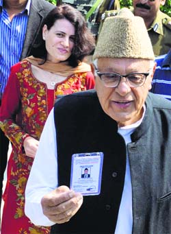 NC candidate Farooq Abdullah shows his voter identity card before casting his vote in Srinagar on Wednesday.