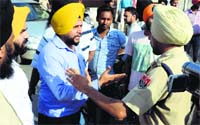 An Akali leader argues with a police official at Kot Mangal Singh in Ludhiana; and (below) a car damaged in the clash. Tribune photos: Himanshu Mahajan