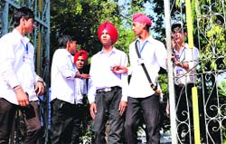 Students of SPS Govt High School (Boys) at Gill man the school gate during polling.