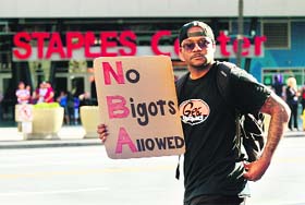 A fan holds a sign in protest outside Staples Center prior to Game 5 of the first-round NBA playoff between the LA Clippers and the Golden State Warriors in Los Angeles on Tuesday