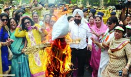 Activists of Delhi Pradesh Mahila Congress burn an effigy of Baba Ramdev in New Delhi on Thursday.