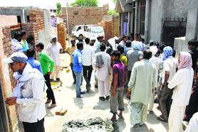People at the scene of a clash between two groups at Sisar Khas village in Rohtak on Thursday. 