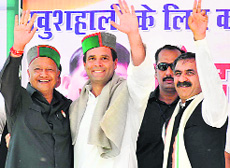 Congress vice-president Rahul Gandhi and Himachal CM Virbhadra Singh wave during an election rally in Bilaspur on Thursday.