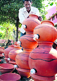 A vendor adjusts the tap of an earthen pot as he awaits customers in Jalandhar
