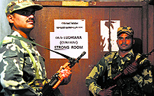 Personnel of paramilitary forces stand guard outside a strong room at the PAU