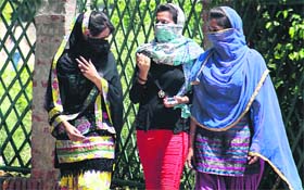 Girls cover themselves with dupattas in the scorching heat in Jalandhar on Thursday. 