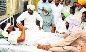 Manpreet Badal visits an injured supporter at the Civil Hospital, Bathinda, on Thursday.