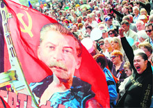 A pro-Russia activist holds a flag depicting Stalin with a machine gun in his hands during a rally in Donetsk on Thursday
