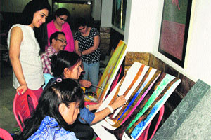 Artists participate in an art competition at Kala Art Gallery in Amritsar on Friday.
