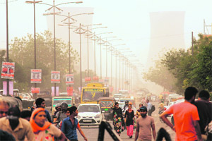 Traffic moves amid a dust storm in Bathinda on Friday.
