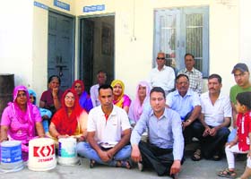 Residents of Bag Malnoo village sit on a dharna outside the office of the IPH Department at Bhawarna in Palampur on Friday