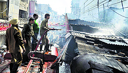 Fire fighters douse flames at a shop in Chaura Bazaar in Ludhiana on Friday