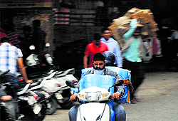 A scooterist struggles to see as a dust storm swept Ludhiana on Friday