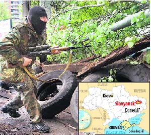 A Pro-Russian gunman runs behind barricades in Slovyansk on Friday. AP/PTI
