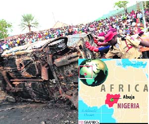 Nigerian security personnel remove the wreckage of a vehicle from the site of a blast at Nyanya bus station on the outskirts of Abuja on Friday. AFP