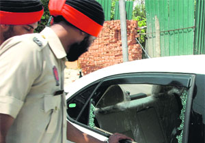 Cops inspect the car from which ~8 lakh was stolen in Amritsar on Saturday.