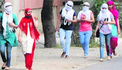 Girls cover their faces to protect themselves from the heat in Bathinda on Saturday. Tribune photo: Pawan Sharma