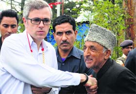 Chief Minister Omar Abdullah shakes hands with a senior party worker during a campaign in Baramulla district on Saturday.