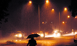 A woman walks amid heavy rain in Sector 18, Chandigarh, on Sunday