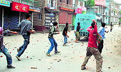 Protesters throw stones at a CRPF vehicle in Srinagar