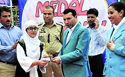 Srinagar Deputy Commissioner Farooq Shah gives away a prize to an athlete on the concluding day of the 5th sub-junior National Tong-il-Moo-Do championship in Srinagar.