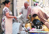 A milk man delivers milk at a house in Amritsar. Photo: RK Soni