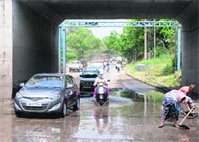 Businessman Gagan Chhabra stands next to the SUV that got stuck at a waterlogged underpass (right) in the Industrial Area, Phase I, Chandigarh, after Sunday evening’s storm