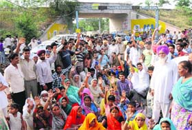 Villagers block road in protest against the opening of a liquor vend at Jagatpura in Mohali on Monday