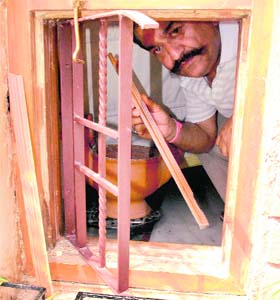 A man shows a broken windowpane at the residence of the victim in Sector 2, Panchkula