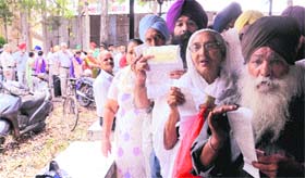 Residents stand in a queue to pay their power bills at a counter of the PSPCL office in the Industrial Area, Phase 1, Mohali, on Monday