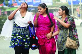 WHAT A RELIEF! Girls caught unawares by the rain in New Delhi on Monday