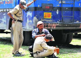 A policeman clearing his ears before going for election duty at Parade Ground in Dehradun on Monday.