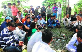 Officials from the local administration persuade protesters from Chaijula Patti to exercise their franchise on Monday.