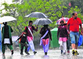 Schoolchildren walk with umbrellas in heavy rain in Shimla on Monday
