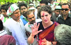 Priyanka Vadra meets villagers during an election campaign in Amethi on Monday. PTI