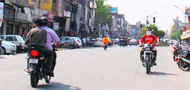 Commuters move on without helmets  in Amritsar on Tuesday.