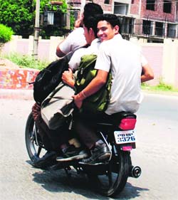 Three youngsters ride on a motorbike against the traffic rules  in Amritsar on Tuesday.