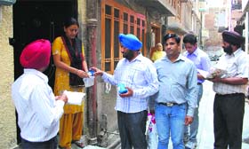 A team of the Health Department distributes chlorine tablets among residents in Amritsar on Tuesday.