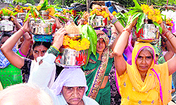 Women take part in a kalash yatra filled with Ganga water