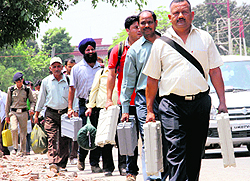 Polling staff with EVM machines leave from the district headquarters for their respective polling centres in Dehradun on Tuesday