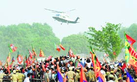Supporters wave at BJP PM nominee Narendra Modi's chopper as it arrives at a rally in Allahabad