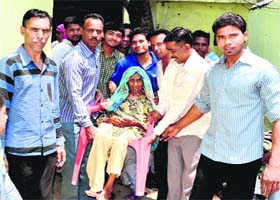 Age no deterrent: Bashrin being taken to a polling booth by her kin in Haridwar on Wednesday