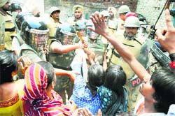 Residents of Ghuman Mandi in Ludhiana protest demolition of their houses on Wednesday. Tribune photo