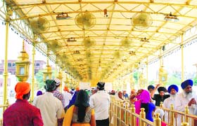 Devotees in a queue under fans in the scorching heat as they come to pay obeisance at the Golden Temple in Amritsar on Thursday.