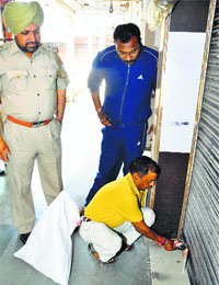 An Estate Office team seals a booth at Krishna Market in Sector 41, Chandigarh, on Thursday.