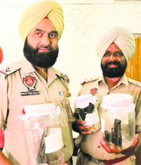 Mohali police officials show arms and jewellery items recovered from the accused on Thursday.