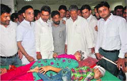 Chief Minister Harish Rawal inquires about the condition of injured bus passenger at Himalayan Hospital in Jolly Grant on Thursday. A Tribune photograph