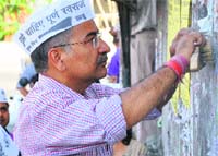 Aam Aadmi Party candidate from Tehri Garhwal Anoop Nautiyal removes poll posters in Dehradun on Thursday. A Tribune photograph