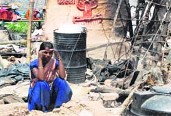 A woman sits dejected after the demolition of her jhuggi in Ambala city on Thursday. A Tribune photograph