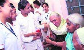 With love: An elderly woman turns nostalgic as students from St. Soldier Nursing College present her a flower on the occasion of Mother's Day in Jalandhar on Thursday